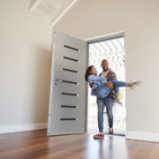 man-carrying-woman-into-new-home-through-stylish-door