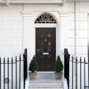 black-traditional-door-behind-trees-and-fence